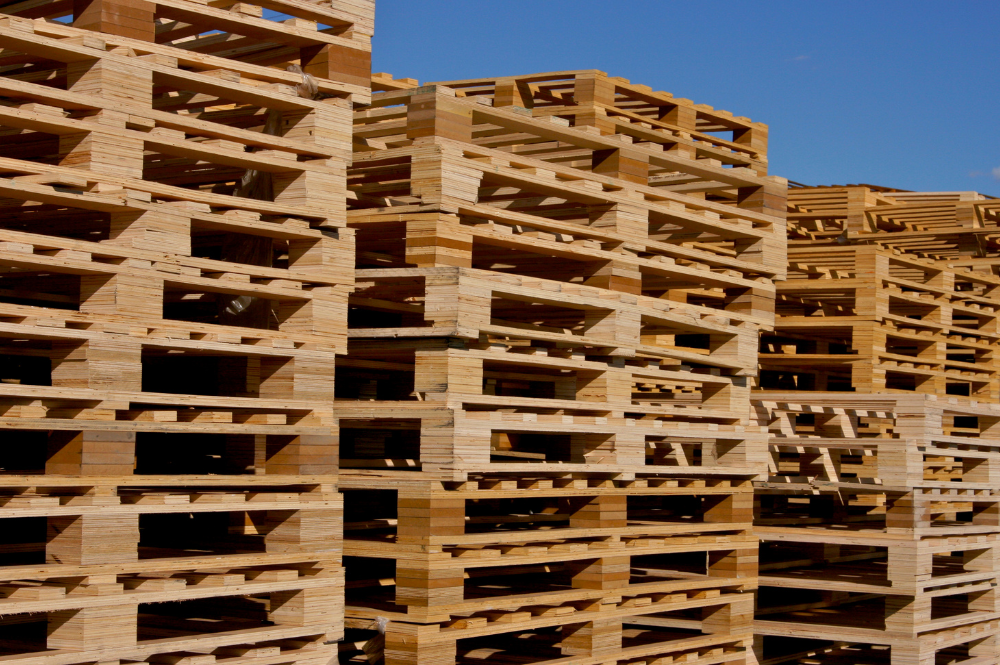 A large stack of FDA-approved wooden pallets arranged neatly in an outdoor setting.