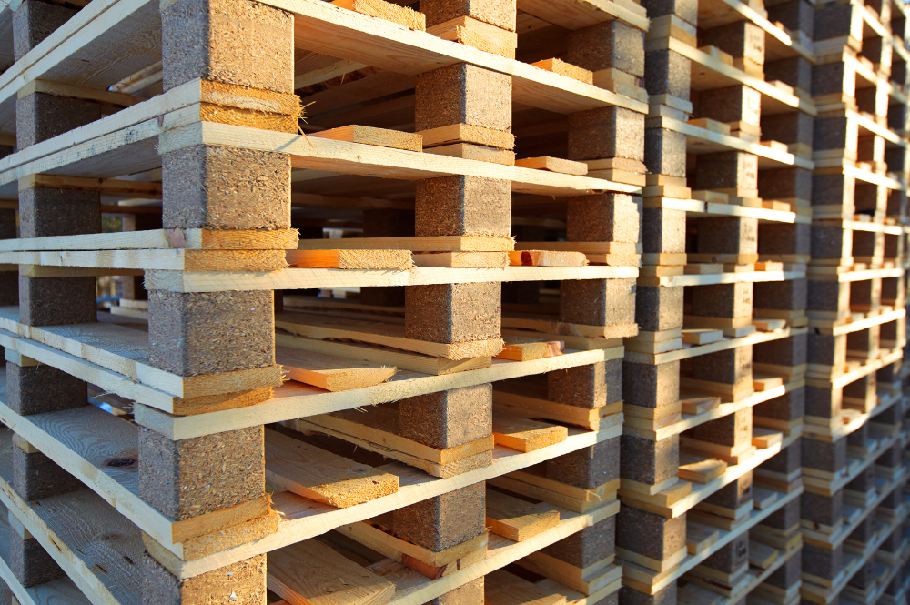 A stack of eco-friendly wooden pallets neatly arranged in a warehouse setting.
